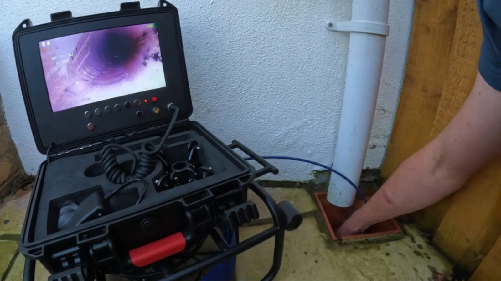 Sewer camera case and cable reel set up on a driveway